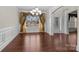 Elegant dining room featuring beautiful chandelier, large window, and hardwood floors at 12515 Hashanli Pl, Matthews, NC 28105