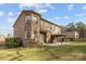 Brick house with a covered patio, grassy area, and manicured lawn at 12515 Hashanli Pl, Matthews, NC 28105