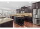 Well-appointed kitchen with dark cabinets, granite counters, and stainless steel refrigerator at 12515 Hashanli Pl, Matthews, NC 28105
