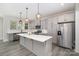 Modern kitchen featuring gray cabinets, stainless steel appliances, and a large island with quartz countertop at 1308 Stone Marker Dr, Monroe, NC 28112