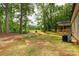 Lush backyard view with mature trees, a utility box, and a cozy covered porch at 1323 Mack Dr, McConnells, SC 29726