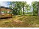 Tranquil backyard featuring mature trees, a wooden porch, and a view of the open field at 1323 Mack Dr, McConnells, SC 29726