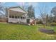 Manicured backyard featuring a covered porch, playhouse and mature trees at 138 Lansdowne Rd, Charlotte, NC 28270