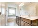 Bright bathroom offers double sinks, a soaking tub, and neutral tile flooring at 14730 Tamarack Dr, Charlotte, NC 28278