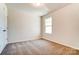 Bedroom featuring neutral carpet, a window for natural light, and a standard closet at 14730 Tamarack Dr, Charlotte, NC 28278