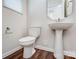 Elegant half bathroom features a pedestal sink and wood-look flooring at 14734 Tamarack Dr, Charlotte, NC 28278