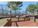 Inviting backyard featuring wooden deck, lush green lawn, mature trees, and wood fence at 152 Painted Bunting Dr, Troutman, NC 28166