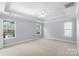 A spacious bedroom with large windows, neutral carpet, and recessed lighting at 152 Painted Bunting Dr, Troutman, NC 28166