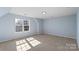 Light-filled bedroom with neutral walls, carpet and a large window with neighborhood view at 152 Painted Bunting Dr, Troutman, NC 28166