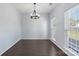 Bright dining room featuring hardwood floors, and a modern chandelier, with natural light coming from the window at 152 Painted Bunting Dr, Troutman, NC 28166