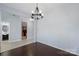Dining room featuring hardwood floors, modern chandelier, and access to the kitchen and bathroom at 152 Painted Bunting Dr, Troutman, NC 28166