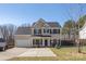 Charming two-story home with a well-manicured lawn, attached garage and black window shutters at 152 Painted Bunting Dr, Troutman, NC 28166