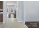 Bright hallway with tile and wood flooring, leading to a sunlit living space with fireplace at 152 Painted Bunting Dr, Troutman, NC 28166