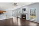 Bright living room with fireplace, hardwood floors, ceiling fan, and kitchen view at 152 Painted Bunting Dr, Troutman, NC 28166