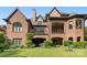 Expansive backyard with manicured lawn, elegant brick architecture, and covered balconies for outdoor enjoyment at 16824 Ashton Oaks Dr, Charlotte, NC 28278