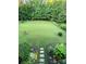 Expansive backyard featuring a lush lawn, manicured garden beds, and a stone pathway at 16824 Ashton Oaks Dr, Charlotte, NC 28278