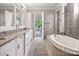 Bathroom featuring a soaking tub, glass enclosed shower, and double vanity at 16824 Ashton Oaks Dr, Charlotte, NC 28278