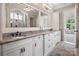 Bathroom with double vanity, granite counters, and an arched mirror overlooking the bedroom at 16824 Ashton Oaks Dr, Charlotte, NC 28278