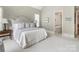 Neutral bedroom with an ensuite bathroom and a quilted blanket on the bed at 16824 Ashton Oaks Dr, Charlotte, NC 28278