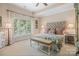 Bright bedroom featuring a tufted headboard, patterned bedding, and a large window at 16824 Ashton Oaks Dr, Charlotte, NC 28278