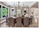 Formal dining room with a large wooden table, chandelier, and ample natural light at 16824 Ashton Oaks Dr, Charlotte, NC 28278