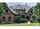 Charming Tudor-style home with brick, stone accents, turret and manicured landscaping at 16824 Ashton Oaks Dr, Charlotte, NC 28278
