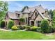Charming two-story home with a turret, brick and stone facade, lush landscaping and a manicured lawn at 16824 Ashton Oaks Dr, Charlotte, NC 28278