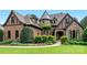 Stunning home with brick and stone exterior, turret, and professional landscaping, creating exceptional curb appeal at 16824 Ashton Oaks Dr, Charlotte, NC 28278