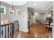 Upstairs hallway featuring hardwood floors, decorative lighting, and a curved staircase at 16824 Ashton Oaks Dr, Charlotte, NC 28278
