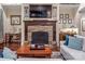 Cozy living room with stone fireplace, hardwood floors and large TV over the mantel at 16824 Ashton Oaks Dr, Charlotte, NC 28278