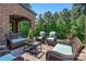 Inviting covered outdoor seating area with wicker furniture and serene wooded views at 16824 Ashton Oaks Dr, Charlotte, NC 28278