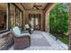 Covered porch with comfortable seating and a view of the lush greenery at 16824 Ashton Oaks Dr, Charlotte, NC 28278