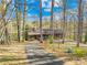 Exterior view of the home through the trees, featuring a driveway and natural setting, blending comfort with nature's beauty at 171 Agnew Rd, Mooresville, NC 28117