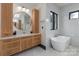 Bright bathroom featuring a soaking tub, marble countertops, modern fixtures, and wood cabinets at 180 Willow Point Rd, Troutman, NC 28166