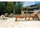 Lake house sandy beach featuring comfortable lounge chairs and a fire pit for relaxing by the water at 180 Willow Point Rd, Troutman, NC 28166