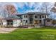 Striking two-story modern home with a combination of stone and white facade, well-manicured lawn, and mature trees at 180 Willow Point Rd, Troutman, NC 28166