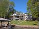 Beautiful multi-level lake house with modern design, expansive windows, dock, and waterfront access on a sunny day at 180 Willow Point Rd, Troutman, NC 28166
