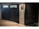 Exterior shot of a garage door with a modern design and complementary exterior lighting at 180 Willow Point Rd, Troutman, NC 28166