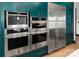 Modern kitchen featuring stainless steel appliances, dark green cabinetry, and built-in ovens for a sleek, efficient design at 180 Willow Point Rd, Troutman, NC 28166