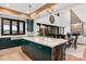 Open-concept kitchen showcasing a marble island, dark green cabinets, stainless steel appliances, and modern fixtures at 180 Willow Point Rd, Troutman, NC 28166