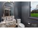 Stylish powder room with marble sink, unique mirror, modern toilet, dark walls, and a view outside at 180 Willow Point Rd, Troutman, NC 28166