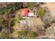 Bird's eye view of a home with a bright red roof, complemented by metal outbuildings and mature trees at 1888 Usher Rd, Lancaster, SC 29720