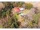 An aerial view of a home with a red roof, metal garages, and a firepit surrounded by a wooded landscape at 1888 Usher Rd, Lancaster, SC 29720