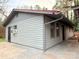 Side exterior view of home featuring light gray wood paneling, dark trim, and a red roof with gutters at 1888 Usher Rd, Lancaster, SC 29720