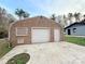View of brick quonset-hut style garage with white door, and the house next to it, with a concrete driveway at 1888 Usher Rd, Lancaster, SC 29720