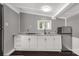 Bright kitchen area featuring gray walls, white cabinets, gas cooktop, and stainless steel fridge at 1888 Usher Rd, Lancaster, SC 29720