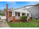 Brick home with covered front porch, showcasing its architectural details and well-maintained lawn at 2125 Shenandoah Ave, Charlotte, NC 28205