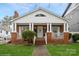 Inviting brick home with a cozy front porch, offering a glimpse of comfortable suburban living at 2125 Shenandoah Ave, Charlotte, NC 28205