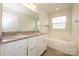 Bathroom featuring double sinks, granite countertops, and a soaking tub at 2692 Norman Isle Dr, Denver, NC 28037