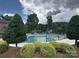 Community pool area featuring lounge chairs, mature trees, and a view of the lake at 2692 Norman Isle Dr, Denver, NC 28037